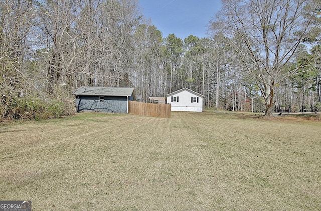 view of yard with an outbuilding and fence