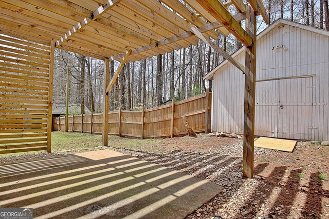 view of patio / terrace with an outbuilding and fence