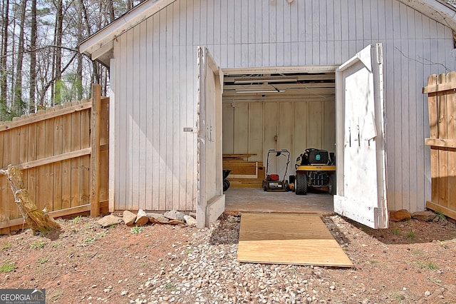 view of shed with fence and a garage