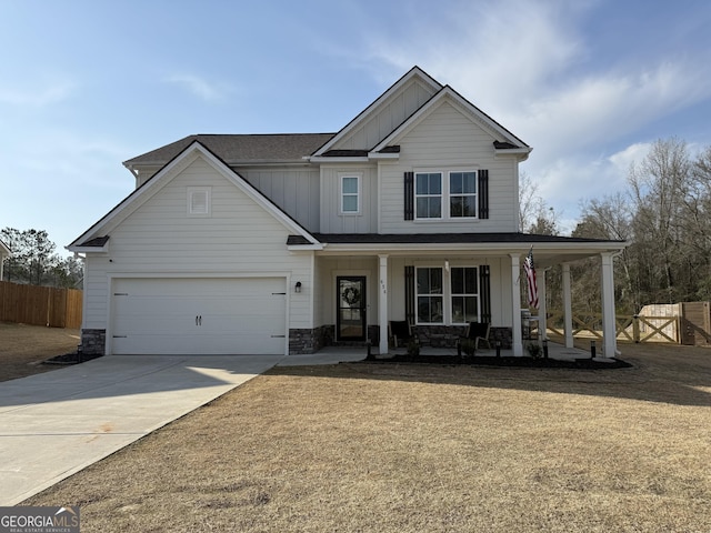 craftsman-style house with board and batten siding, fence, covered porch, a garage, and driveway