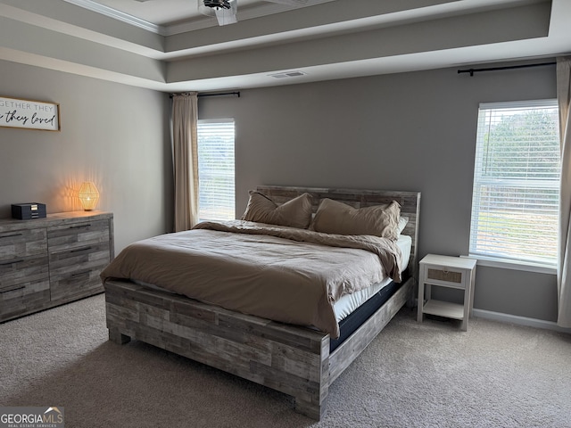 bedroom featuring a raised ceiling, crown molding, visible vents, and carpet floors