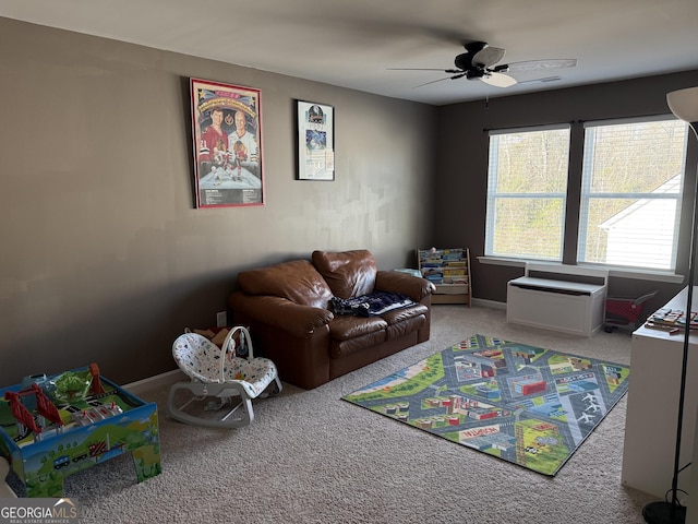 recreation room with carpet flooring, a ceiling fan, and baseboards