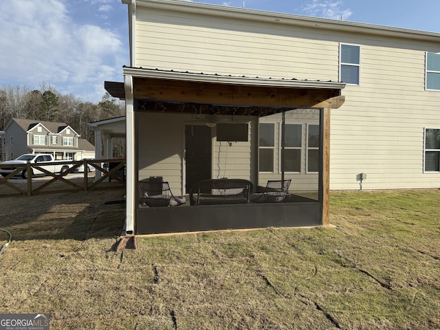 rear view of house with a yard and fence