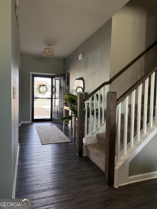 foyer featuring stairs, baseboards, and wood finished floors