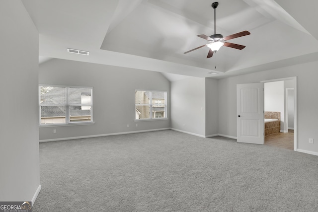 interior space featuring baseboards, visible vents, a tray ceiling, ceiling fan, and carpet flooring