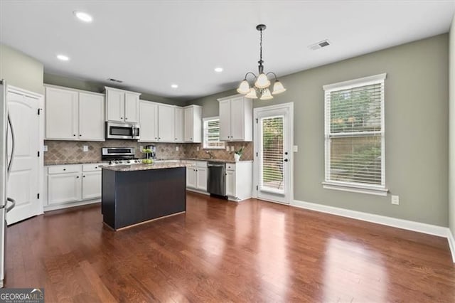 5310 Corinth Ct, Cumming, GA 30040 - kitchen with tasteful backsplash, visible vents, a notable chandelier, appliances with stainless steel finishes, and dark wood-type flooring