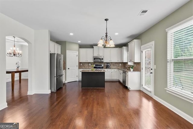 5310 Corinth Ct, Cumming, GA 30040 - kitchen with visible vents, an inviting chandelier, stainless steel appliances, decorative backsplash, and a kitchen island