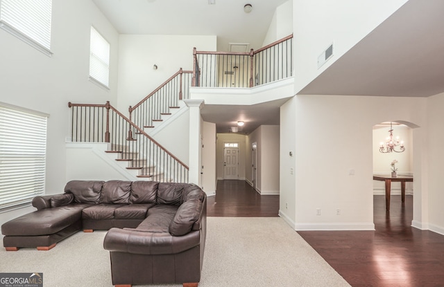 5310 Corinth Ct, Cumming, GA 30040 - living room with dark wood finished floors, arched walkways, visible vents, stairway, and a chandelier