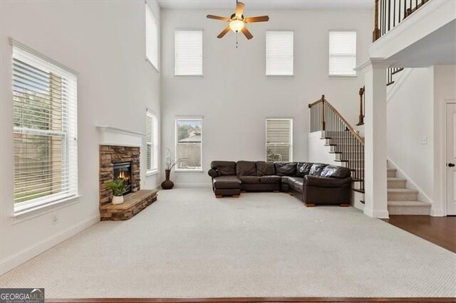 5310 Corinth Ct, Cumming, GA 30040 - living room featuring a ceiling fan, a towering ceiling, stairway, and a fireplace