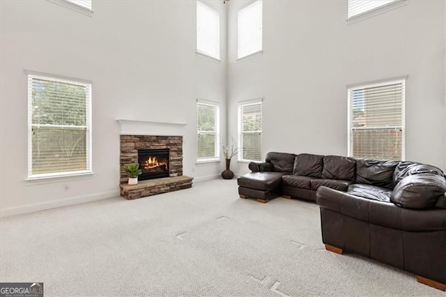 5310 Corinth Ct, Cumming, GA 30040 - living room featuring carpet, a high ceiling, a stone fireplace, and baseboards