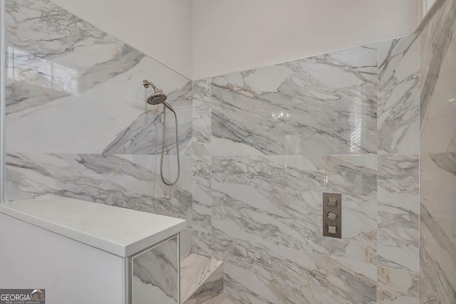 full bathroom with a marble finish shower