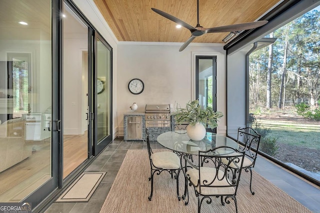 sunroom featuring a ceiling fan and wood ceiling