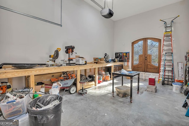 garage featuring a workshop area, a garage door opener, and french doors