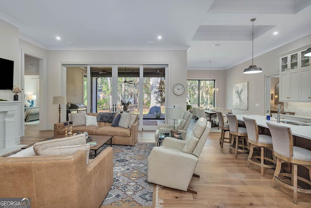 living room with recessed lighting, visible vents, crown molding, and light wood finished floors