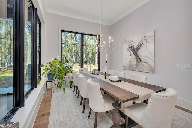 dining space with an inviting chandelier, wood finished floors, baseboards, and ornamental molding