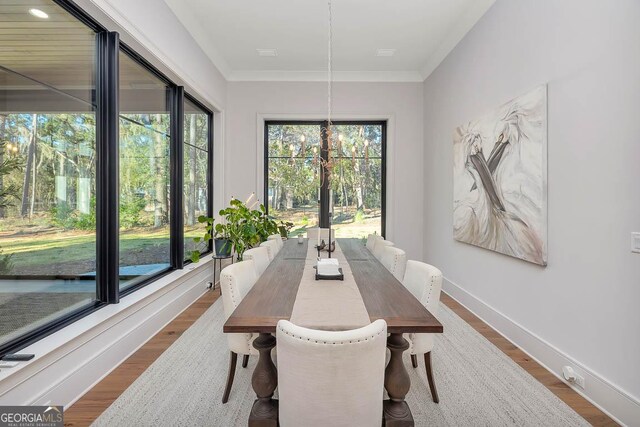 dining room with dark wood-type flooring, baseboards, and ornamental molding