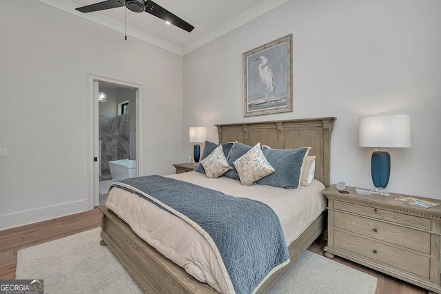 bedroom featuring wood finished floors, baseboards, ensuite bath, ceiling fan, and ornamental molding