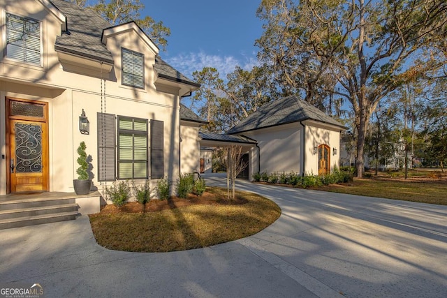 view of property exterior with stucco siding and driveway