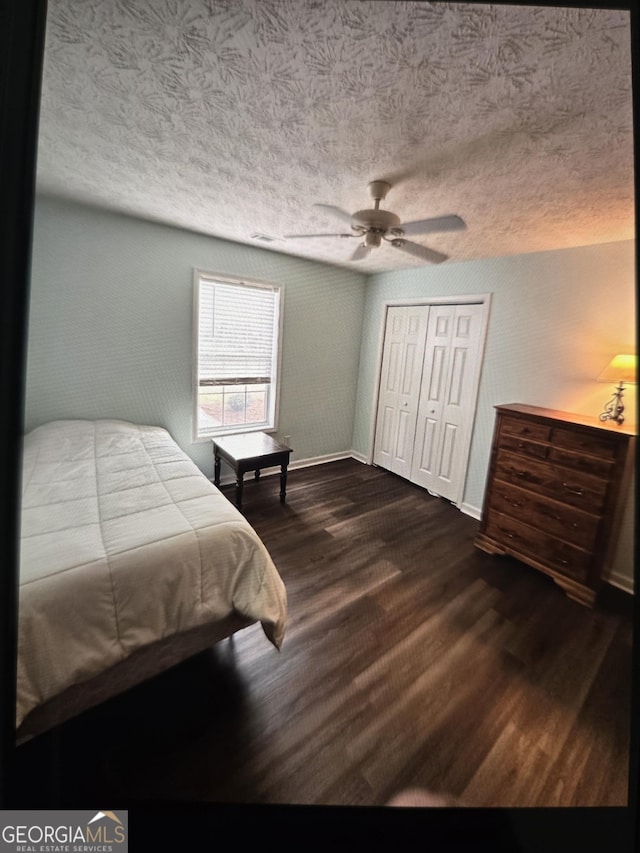 332 Black Willow Ct, Locust Grove, GA 30248 - bedroom with dark wood-style flooring, a textured ceiling, baseboards, a closet, and a ceiling fan