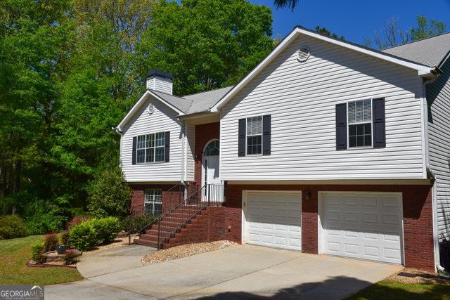 332 Black Willow Ct, Locust Grove, GA 30248 - split foyer home with a garage, brick siding, driveway, and a chimney