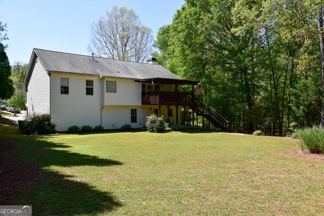 332 Black Willow Ct, Locust Grove, GA 30248 - rear view of property with stairs, a lawn, a wooden deck, and metal roof