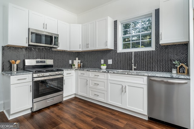 kitchen with light stone countertops, ornamental molding, dark wood-style floors, stainless steel appliances, and a sink