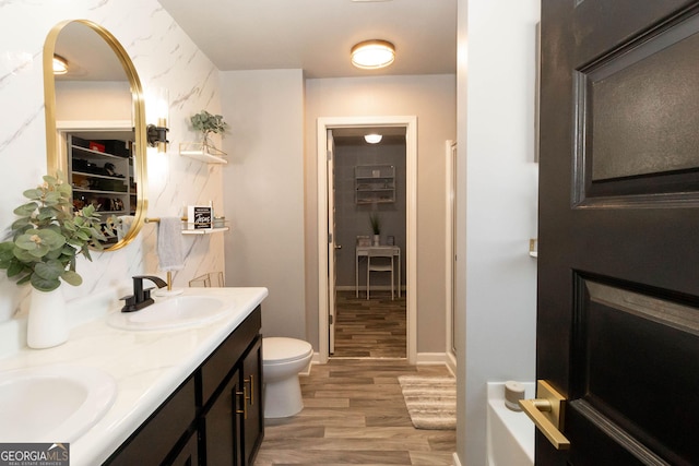 full bathroom featuring a sink, toilet, wood finished floors, and double vanity