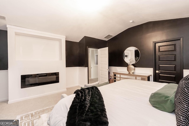 bedroom featuring visible vents, lofted ceiling, and carpet flooring