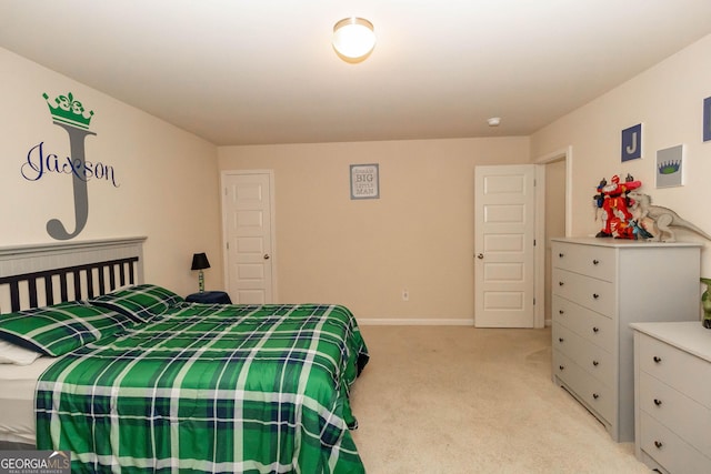 bedroom with light colored carpet and baseboards