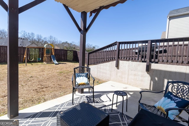 view of patio with a playground and a fenced backyard