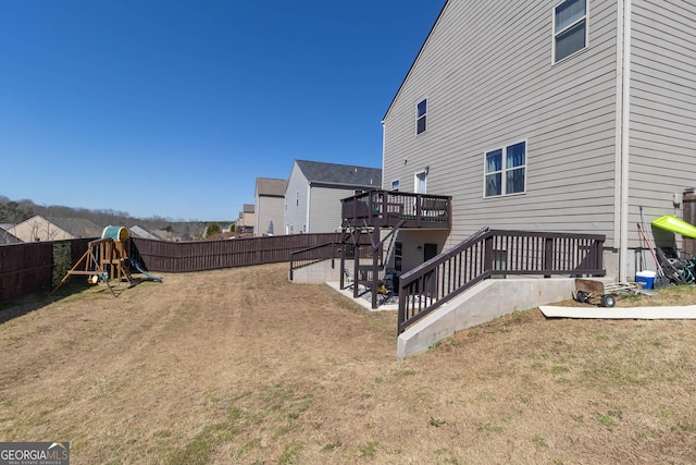 view of yard with a patio area, a wooden deck, a playground, and a fenced backyard