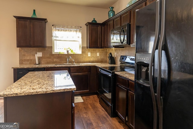 kitchen featuring dark wood-style floors, a sink, black appliances, backsplash, and a center island