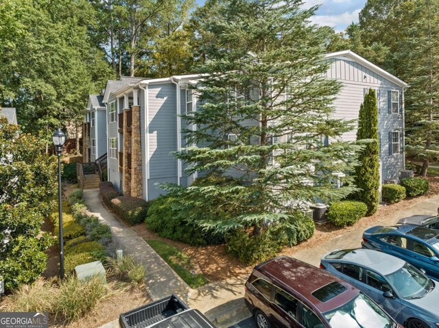 view of property exterior with uncovered parking