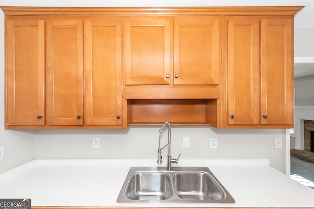 75 Heatherstone Way, Covington, GA 30016 - kitchen with light countertops, a fireplace with raised hearth, open shelves, and brown cabinetry