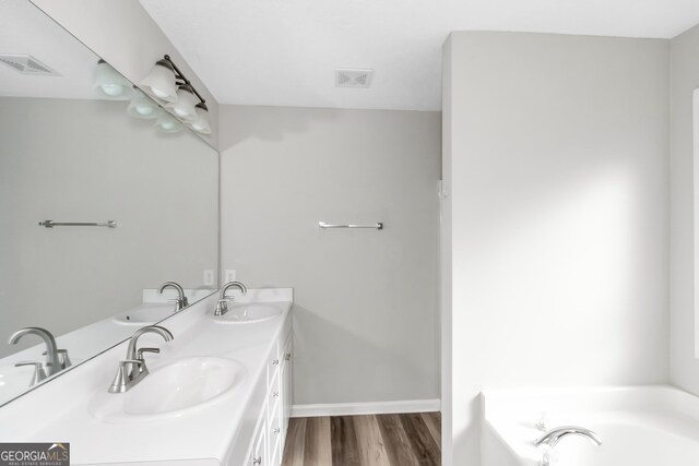 75 Heatherstone Way, Covington, GA 30016 - bathroom featuring double vanity, wood finished floors, and a bath