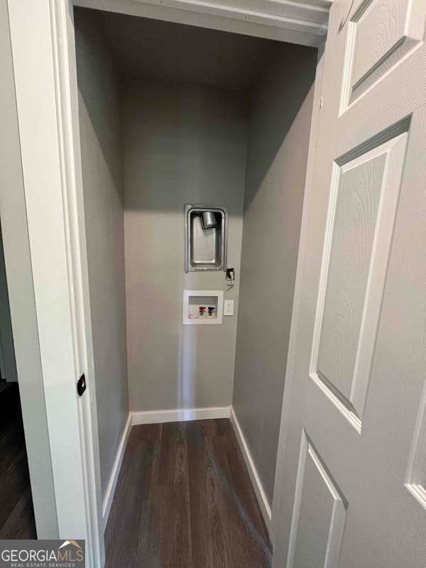 laundry area featuring dark wood finished floors, laundry area, baseboards, and washer hookup