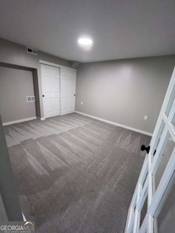 unfurnished bedroom with a closet, visible vents, baseboards, and carpet