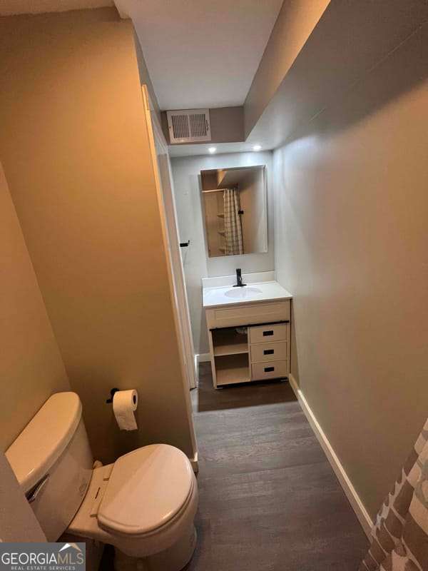 full bathroom with visible vents, baseboards, toilet, and vanity