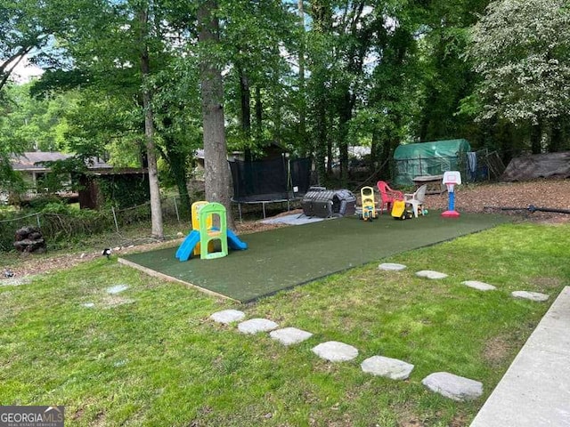 view of jungle gym featuring a trampoline and a yard