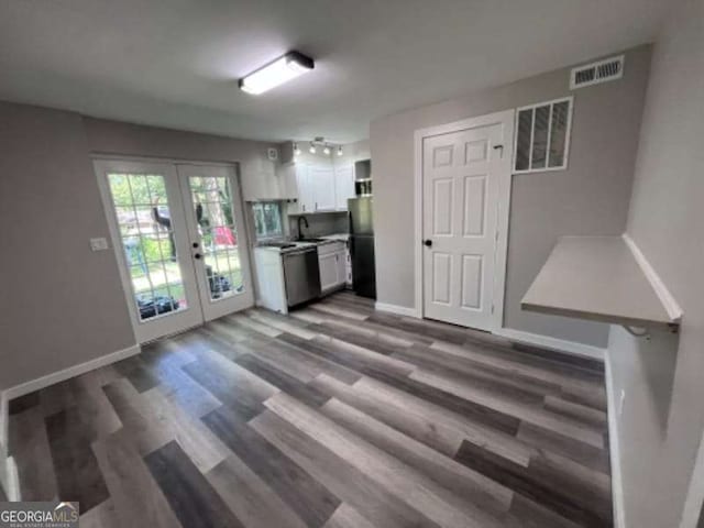 kitchen featuring visible vents, a sink, white cabinetry, freestanding refrigerator, and french doors