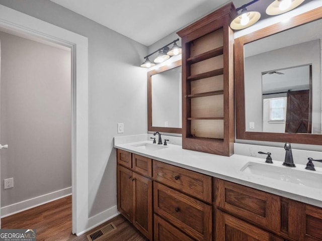 full bathroom with visible vents, wood finished floors, baseboards, and a sink