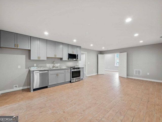 kitchen featuring light wood-type flooring, stainless steel appliances, visible vents, and gray cabinetry