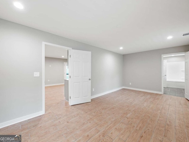 spare room with recessed lighting, light wood-style floors, and baseboards