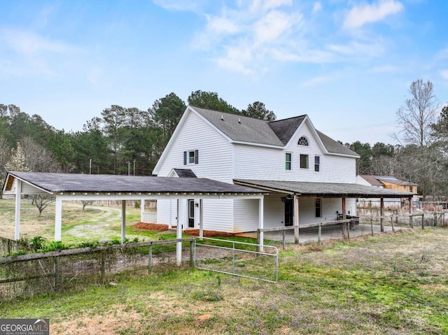 back of property featuring roof with shingles and fence