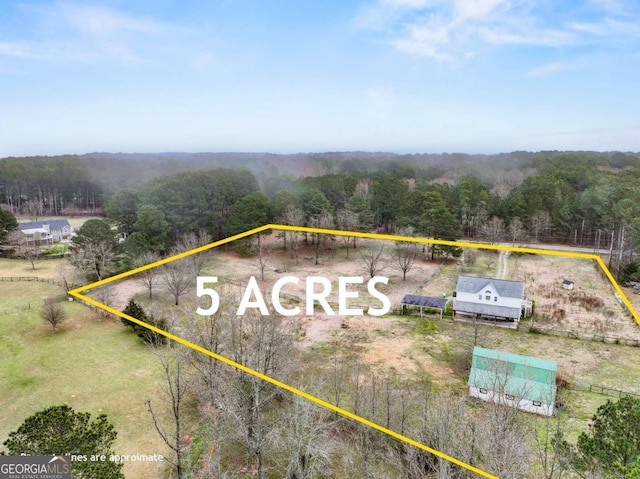 birds eye view of property with a rural view and a wooded view