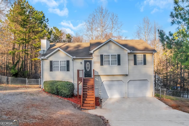 view of front of home featuring a chimney, concrete driveway, an attached garage, and fence