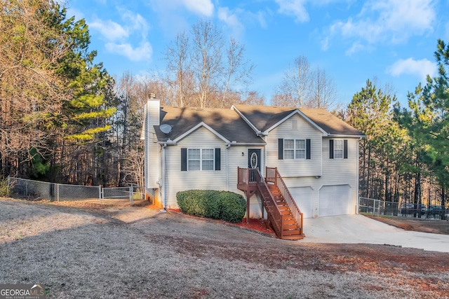 view of front facade with concrete driveway, a chimney, a garage, and fence