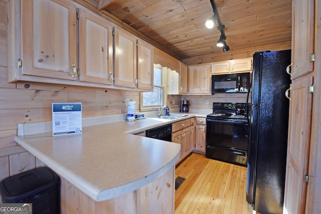 kitchen featuring light countertops, a peninsula, wooden ceiling, light wood-style floors, and black appliances