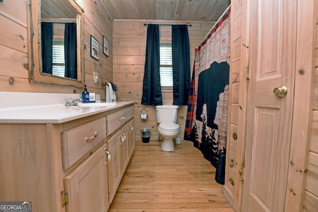 bathroom featuring vanity, wooden walls, wood finished floors, wood ceiling, and toilet