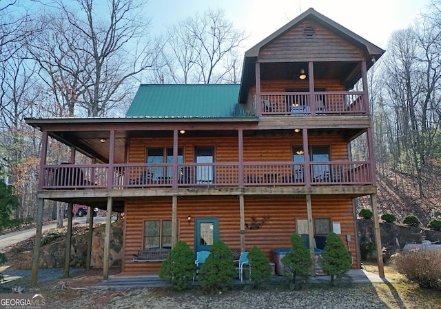 back of house featuring log veneer siding and a balcony